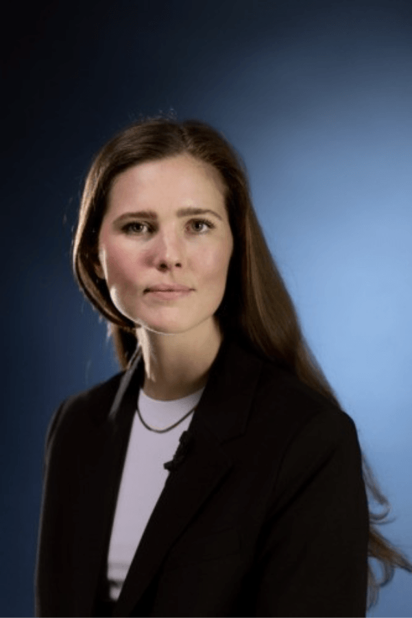 Person with long brown hair in a black blazer and white shirt, face blurred, on a blue gradient background